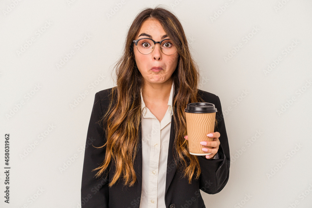 Young caucasian business woman holding a takeaway coffee isolated on white background shrugs shoulders and open eyes confused. Young caucasian business woman holding a takeaway coffee isolated on white background shrugs shoulders and open eyes confused.