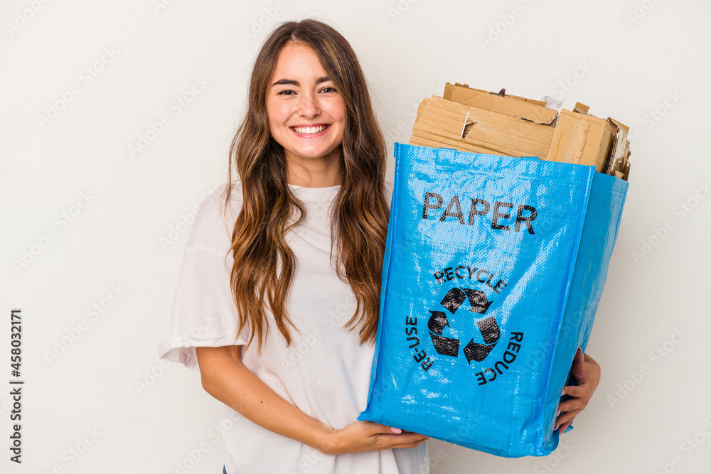 Young caucasian woman recycling paper isolated on white background happy, smiling and cheerful. Young caucasian woman recycling paper isolated on white background happy, smiling and cheerful.