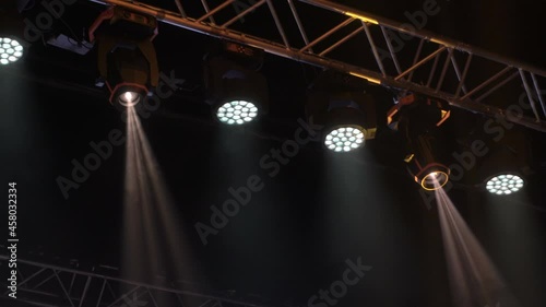 Animation of stage lights frame. Bright shiny stage lights flashing movement entertainment spotlight projectors in the dark, multicolored soft light spotlight strike on black background.