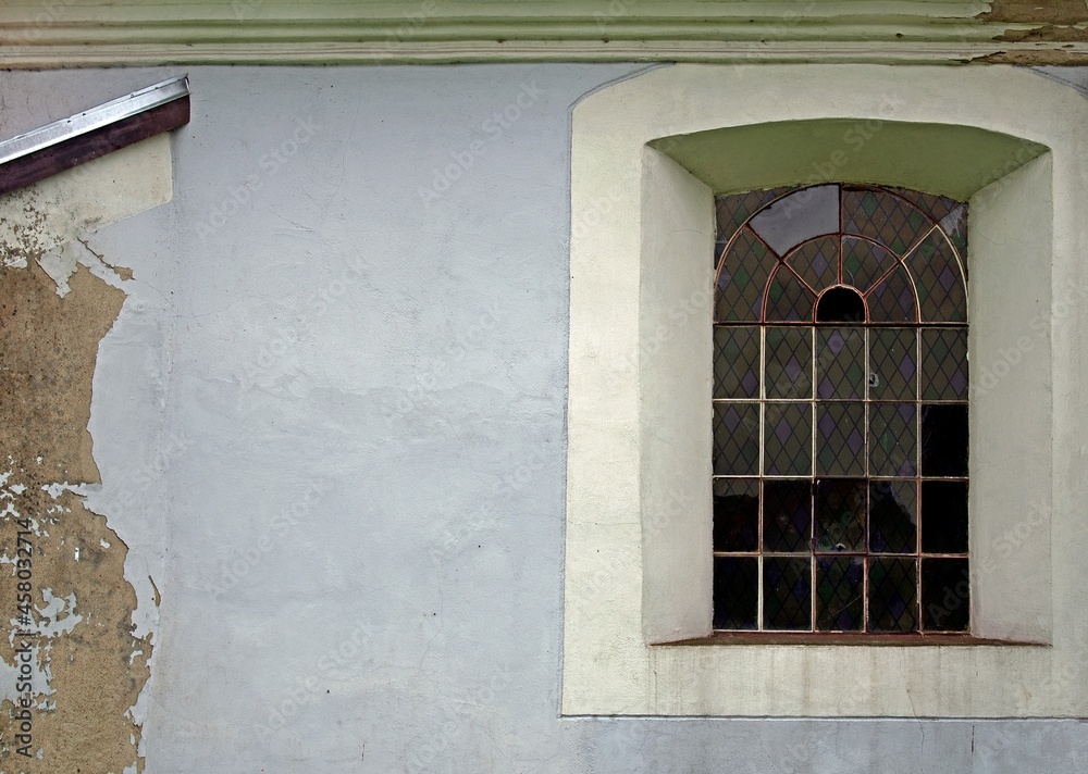 Fototapeta premium General view and architectural details of the Protestant church built in plastered red brick at the beginning of the 19th century in the village of Rańsk in Masuria, Poland.
