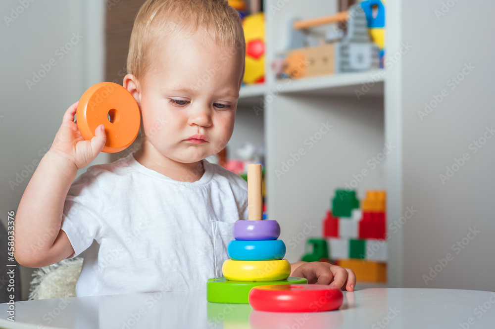 Handsome toddler plays with wooden toys in kindergarten or in children's room close-up and copy space... Handsome toddler plays with wooden toys in kindergarten or in children's room close-up and copy space...