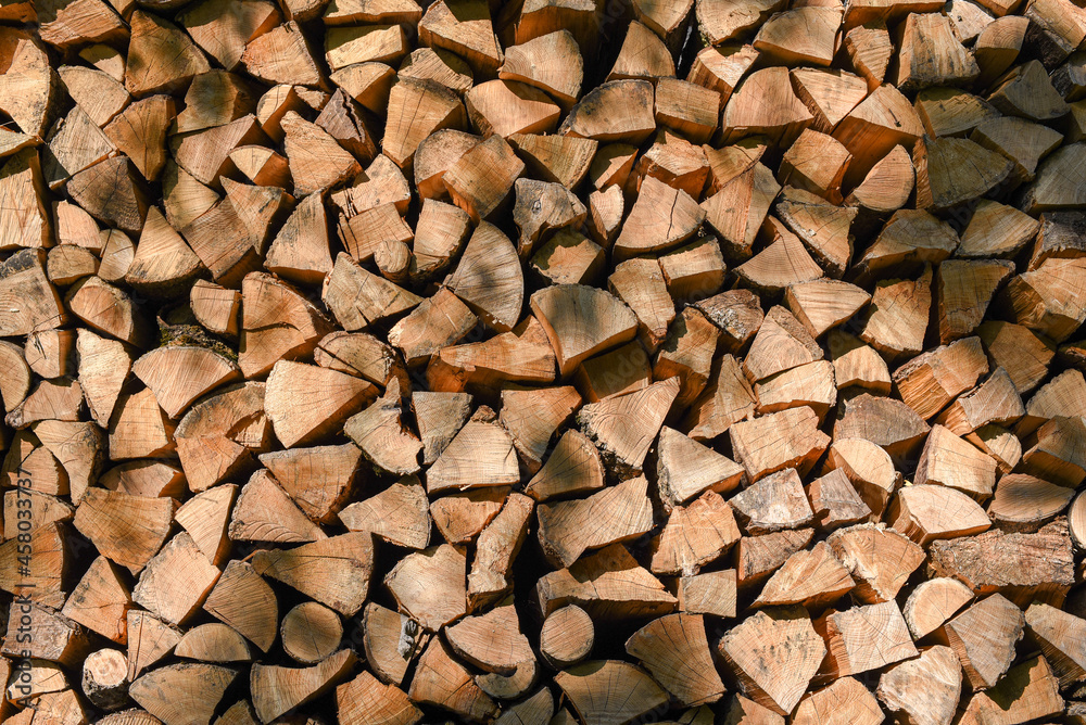 A wall with neatly stacked chopped pieces of firewood A wall with neatly stacked chopped pieces of firewood