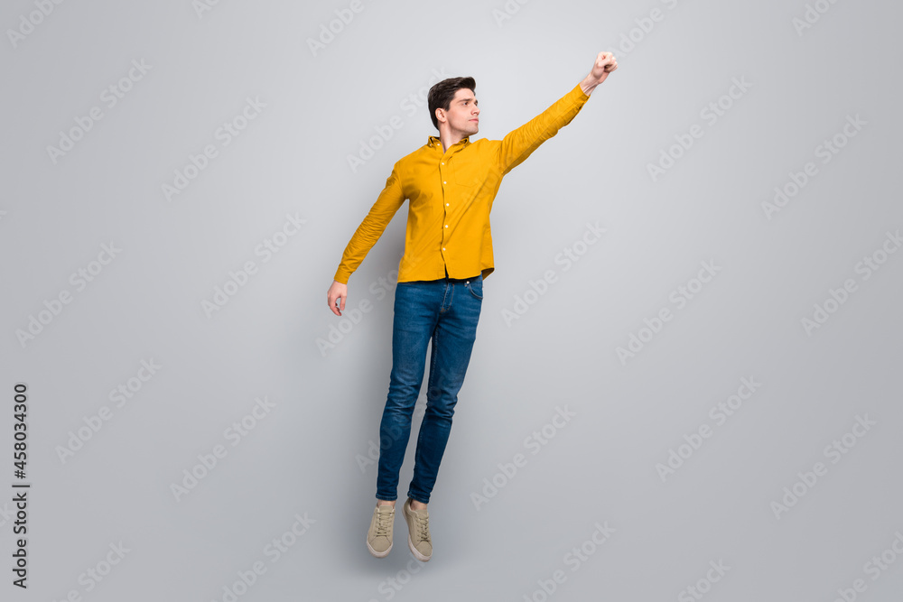 Full length body size view of attractive man jumping flying save resque isolated over grey color background Full length body size view of attractive man jumping flying save resque isolated over grey color background
