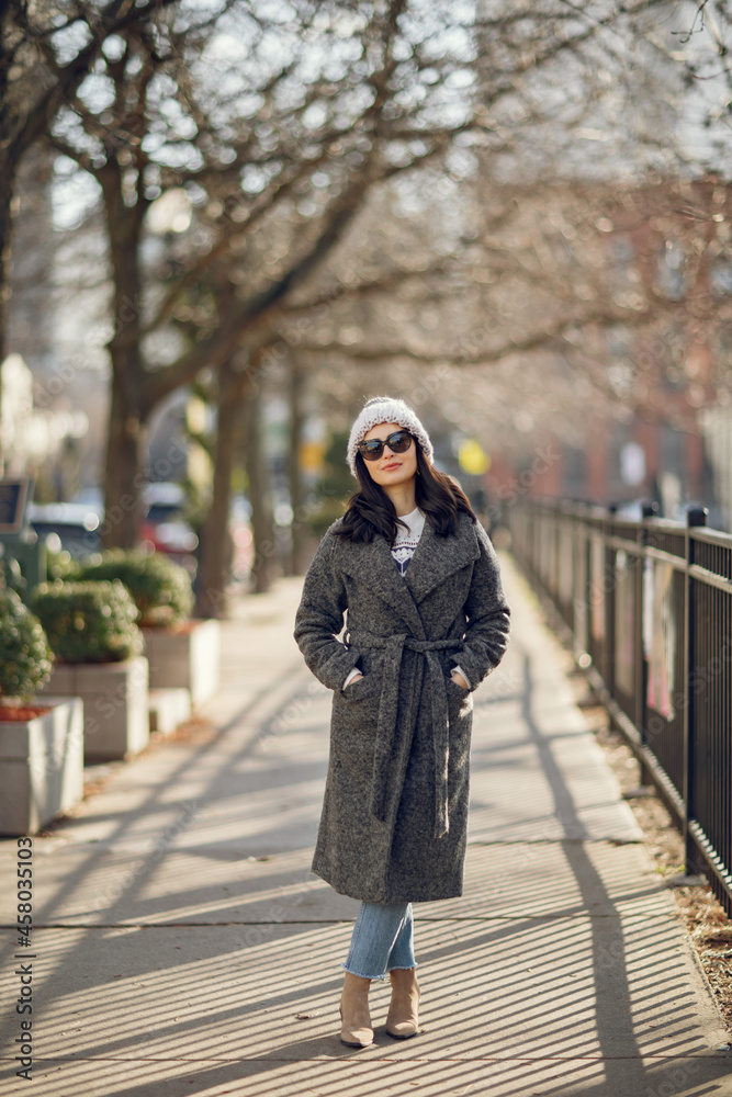 Elegant girl walk in a winter city. Woman in a white knited sweater. Beautiful lady with dark hair. Elegant girl walk in a winter city. Woman in a white knited sweater. Beautiful lady with dark hair.