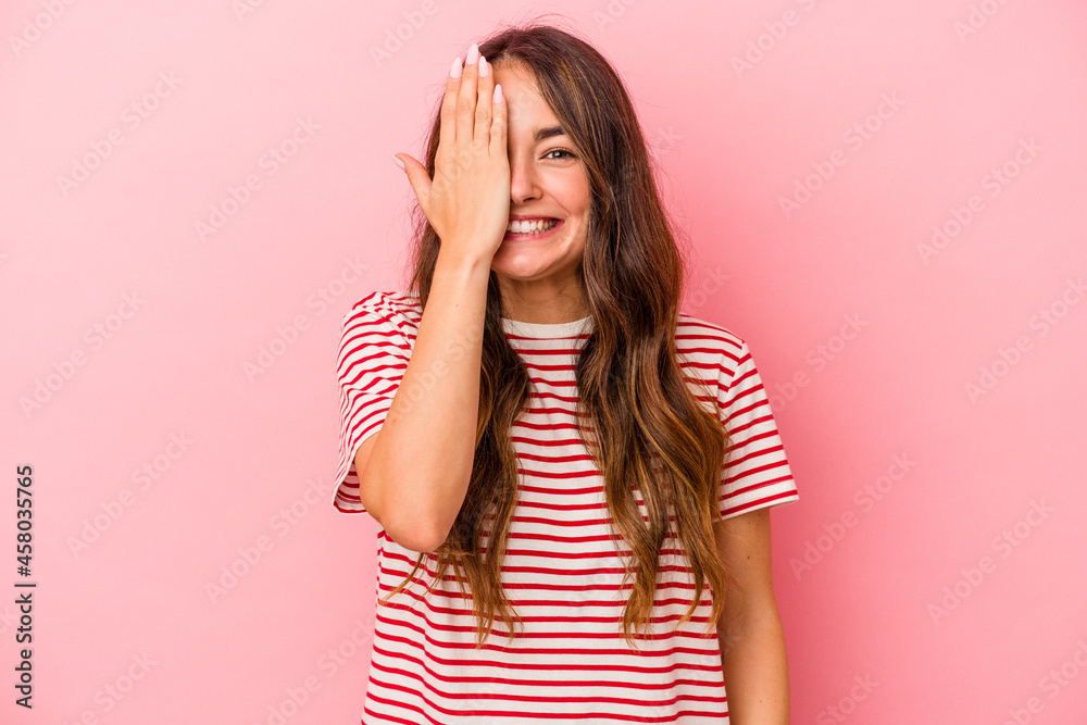 Young caucasian woman isolated on pink background having fun covering half of face with palm. Young caucasian woman isolated on pink background having fun covering half of face with palm.