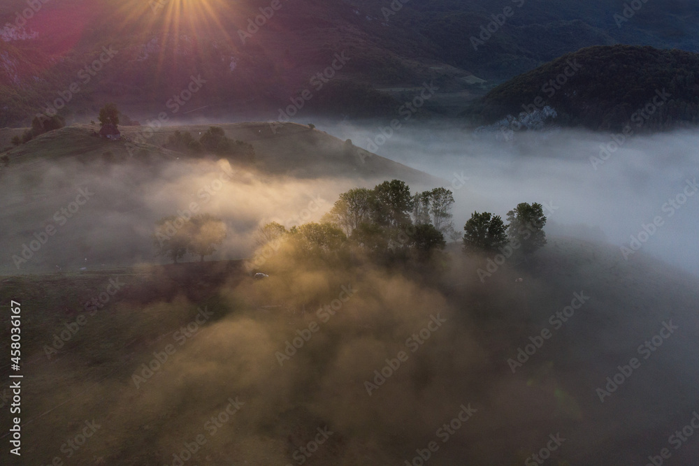Aerial view of mountain landscape with morning fog, at the forest edge, in Romania Aerial view of mountain landscape with morning fog, at the forest edge, in Romania