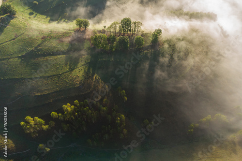 Aerial view of mountain landscape with morning fog  at the forest edge  in Romania