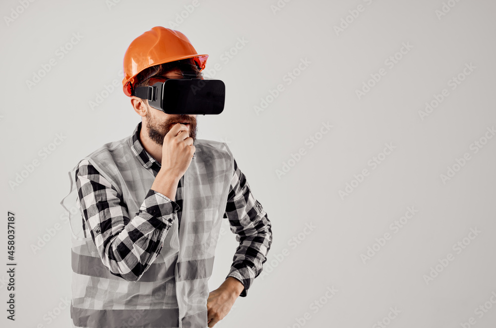 male builder in an orange helmet technology Professional light background male builder in an orange helmet technology Professional light background
