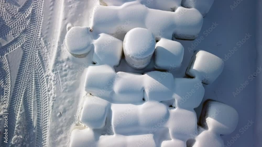Rolls of hays covered with thick white snow in Finland during the winter season in the city Rolls of hays covered with thick white snow in Finland during the winter season in the city