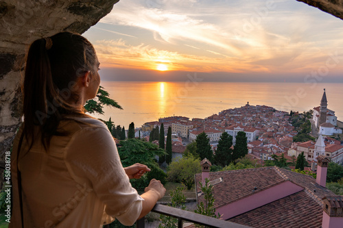 blurred tourist woman watching the beautiful sunset from the piran city walls Piransko obzidje