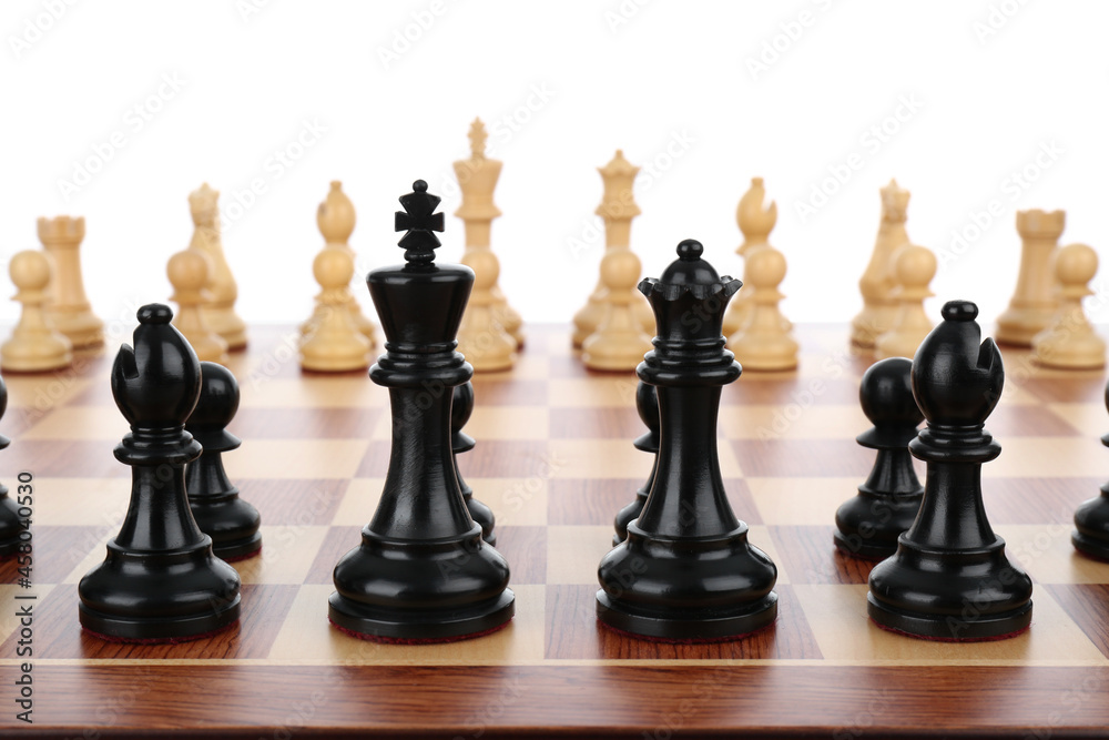 Chess pieces on wooden board against white background Chess pieces on wooden board against white background