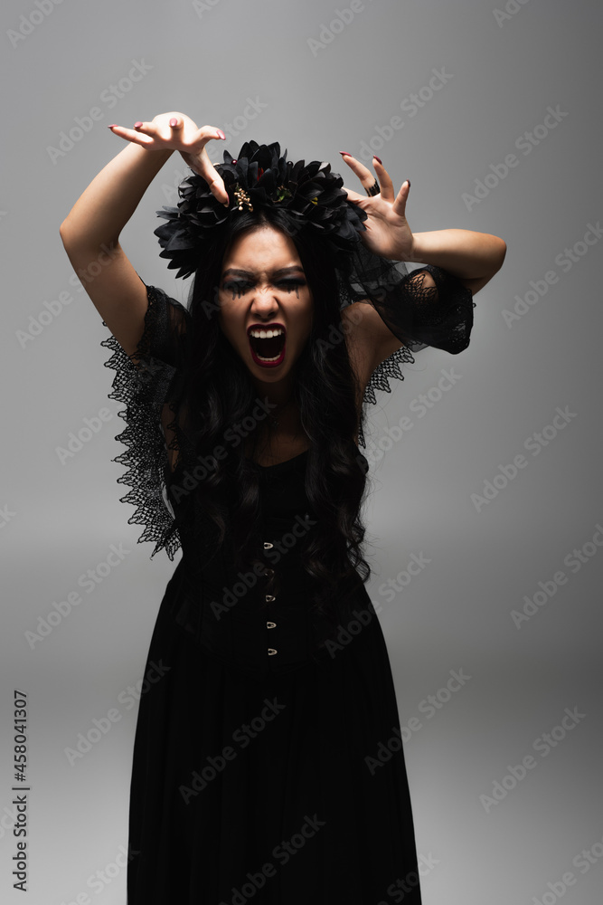 Φωτογραφία asian woman in vampire halloween costume showing scary gesture and growling isol
