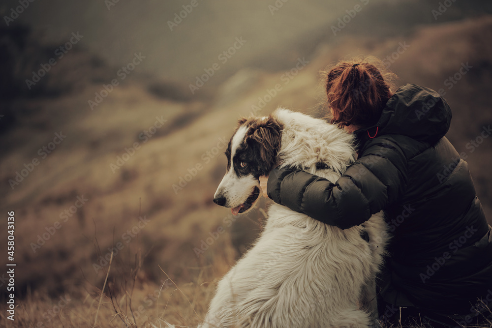 Φωτογραφία Young woman tourist hugging her dog outdoors while hiking with her best friend