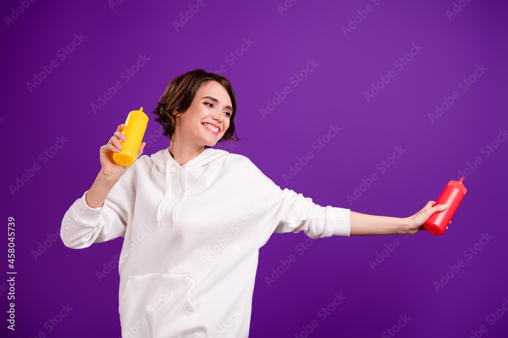 Photo of young good mood positive female dance in cafeteria hold ketchup mustard bottle isolated on purple color background Photo of young good mood positive female dance in cafeteria hold ketchup mustard bottle isolated on purple color background