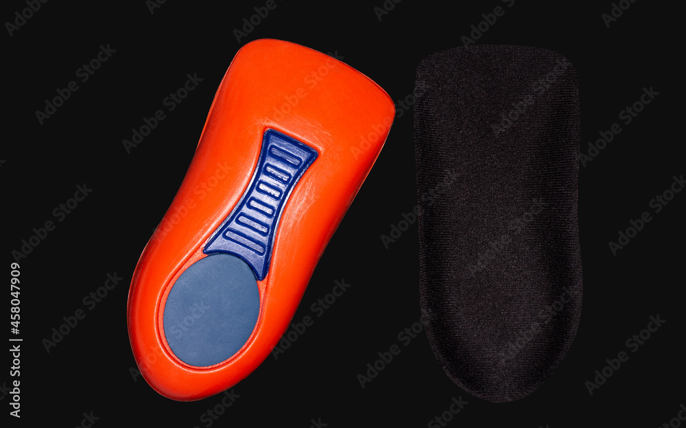 The orthopedic insole on a black background. Treatment and prevention of flat feet and foot diseases The orthopedic insole on a black background. Treatment and prevention of flat feet and foot diseases