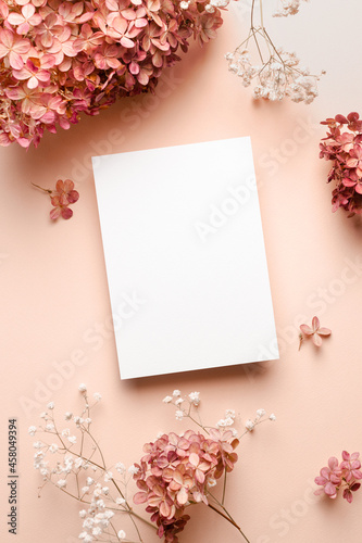 Invitation or greeting card mockup with trendy hydrangea and gypsophila flowers decorations.