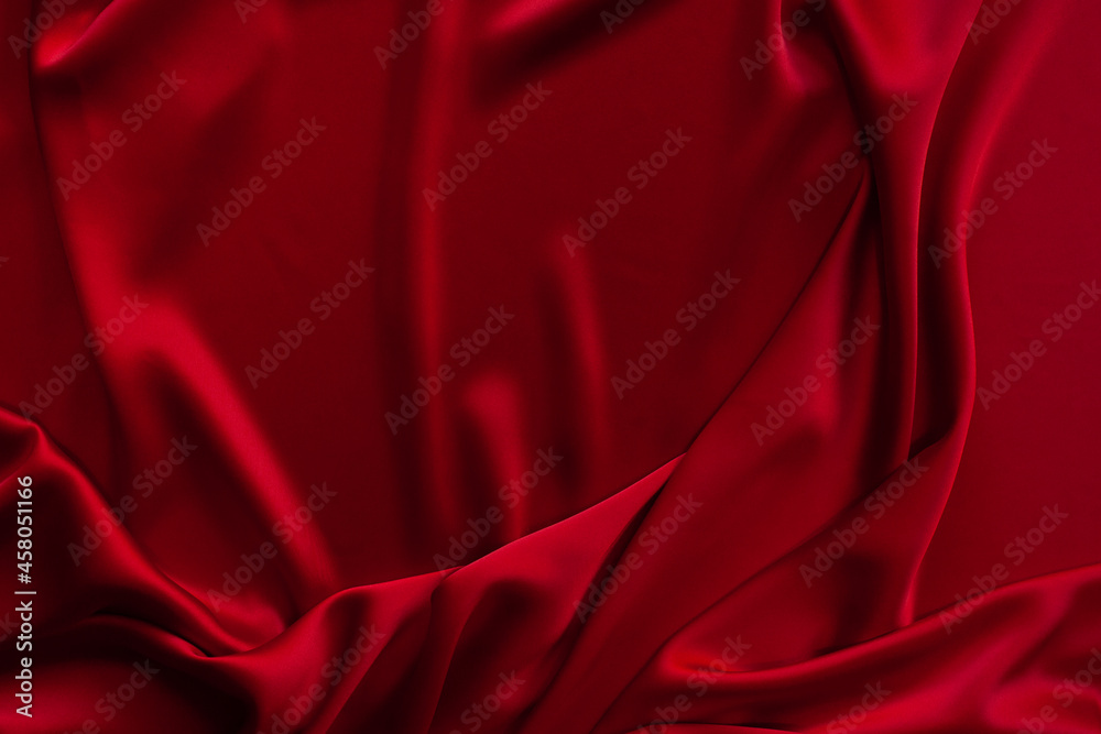 Red fabric texture background. Silk satin folds
