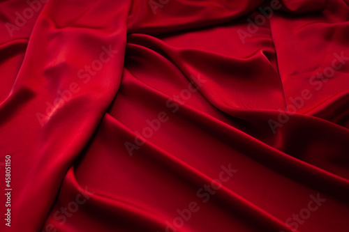 Red fabric texture background. Silk satin folds