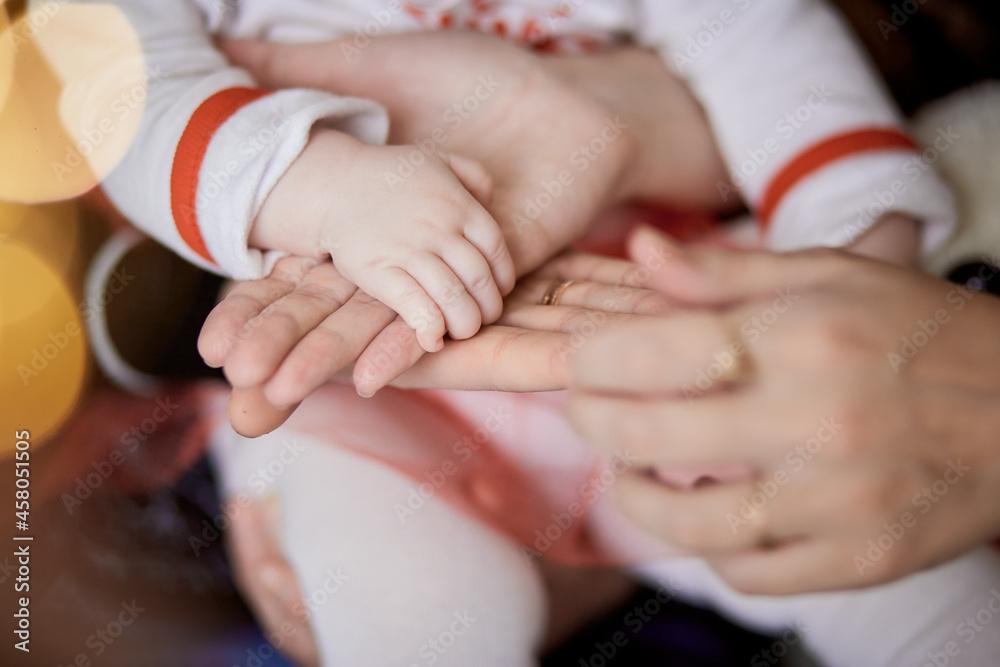 Family keeps hands together. Mother, father and little baby hands close up. Sweet home, tenderness and love together concept Family keeps hands together. Mother, father and little baby hands close up. Sweet home, tenderness and love together concept