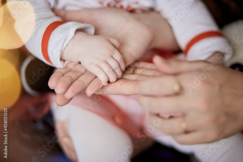 Family keeps hands together. Mother  father and little baby hands close up. Sweet home  tenderness and love together concept