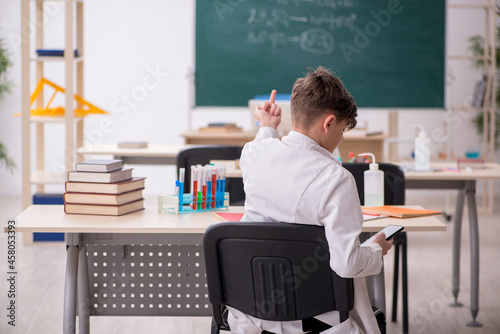Schoolboy studying chemistry in the classroom