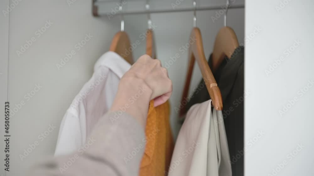 custom made wallpaper toronto digitalWoman hand opens white wardrobe with colorful clothes chooses and takes short-sleeved orange dress and closes closet closeup