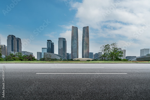 Panoramic skyline and empty asphalt road with modern buildings