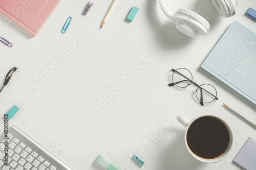 Online learning education, freelance and office work minimalistic flat lay with empty place text and copy space. Stationery, headphones, notebook, pencil, glasses and coffee cup on white background. photo