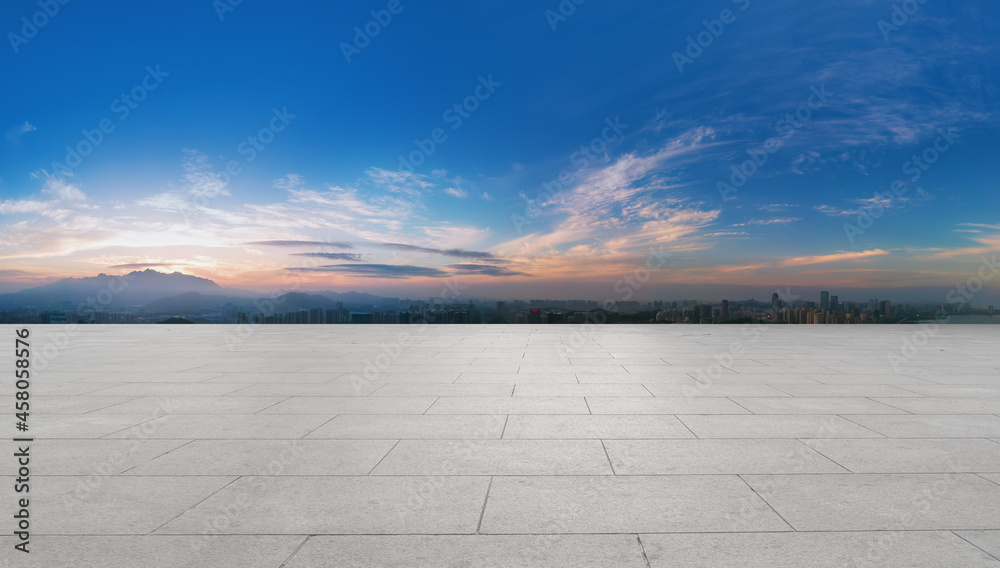 Panoramic skyline and empty square floor tiles with modern buildings