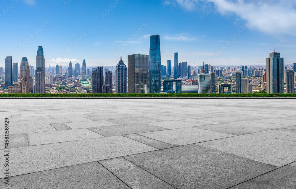 Panoramic skyline and empty square floor tiles with modern buildings