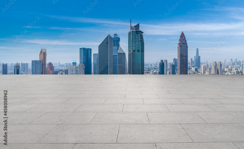 Panoramic skyline and empty square floor tiles with modern buildings