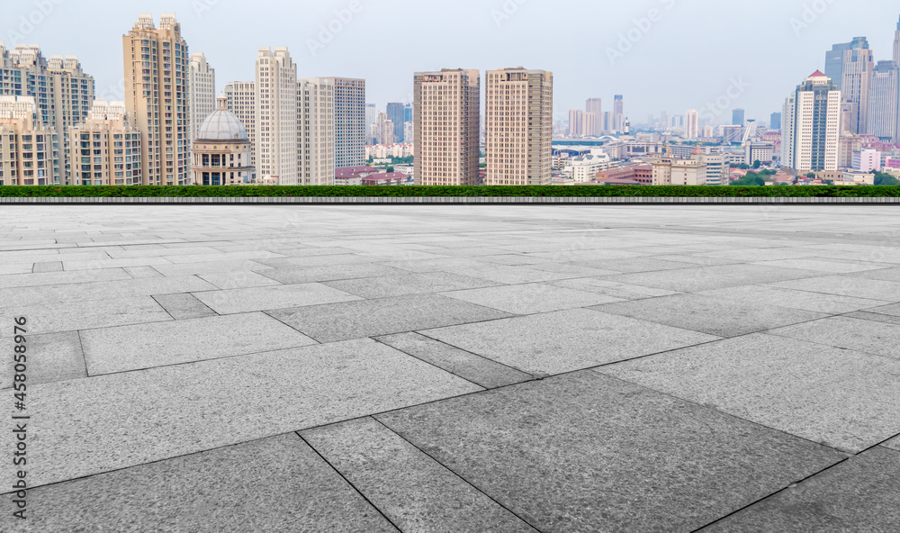 Panoramic skyline and empty square floor tiles with modern buildings