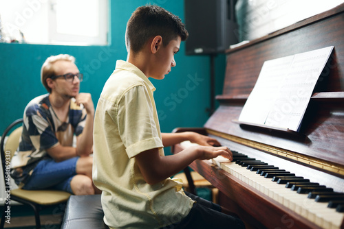 Fotografia, Obraz Boy having a piano lesson at music school
