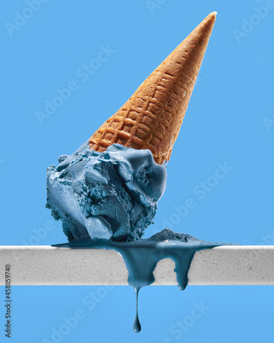 Obraz na plátně Blue ice cream in cone on blue background upside down and melting with drips