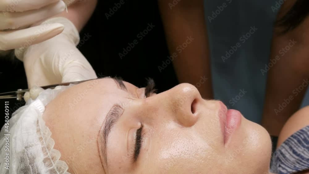 The master draws a new shape of the eyebrows with special pencil. Eyebrow shape correction. Microblading, permanent makeup, tattoo The master draws a new shape of the eyebrows with special pencil. Eyebrow shape correction. Microblading, permanent makeup, tattoo
