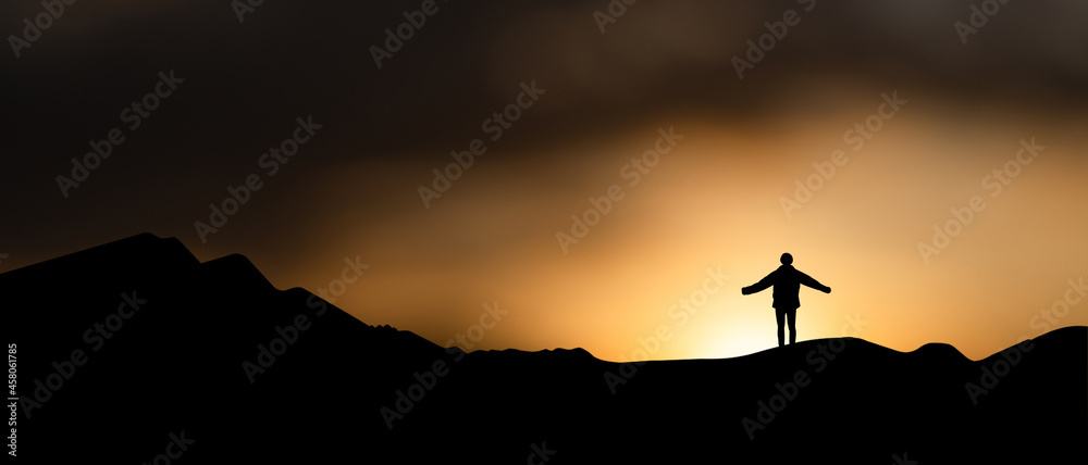 Silhouette of young traveler and backpacker watched beautiful view sunrise alone on top of the mountain. He enjoyed traveling and was successful when he reached the summit.