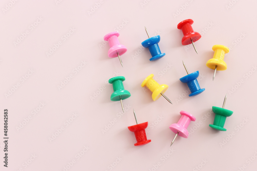 close up of various pushpins on pink background close up of various pushpins on pink background