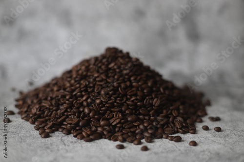 Roasted beans of coffee on grey background