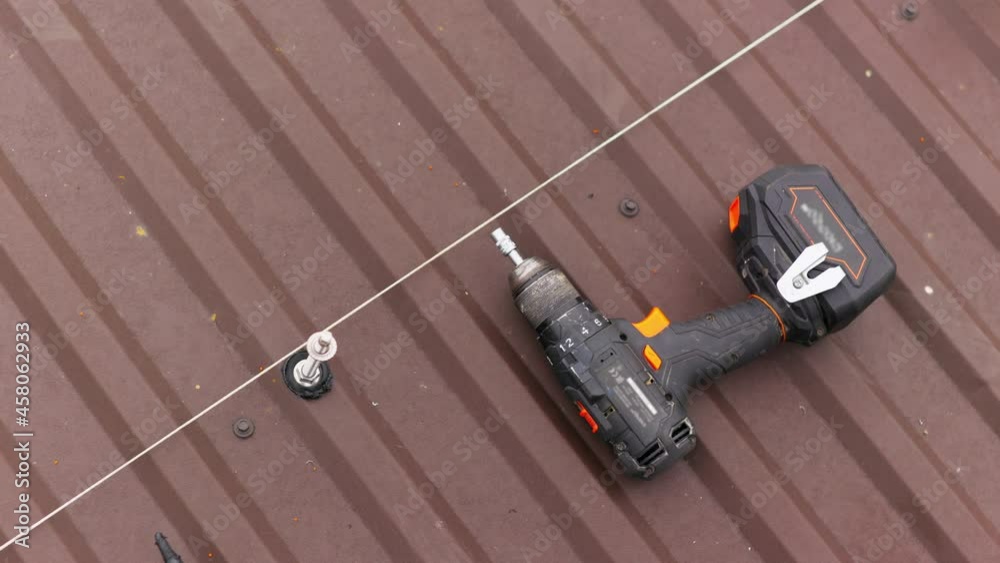 close up tool for roof repair. A screwdriver for tightening bolts and nuts lies on the roof. Installation of mounts for solar panels