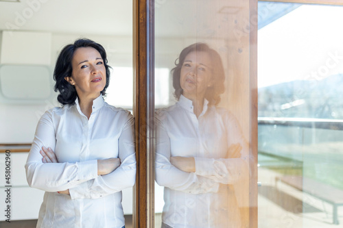 Woman standing near glass door at home