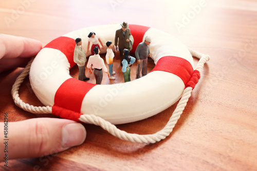 Concept image of life buoy protecting group of people. Rescue and support in times of crisis metaphor photo