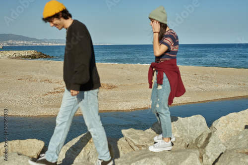 Two engaged young people walking on rocks