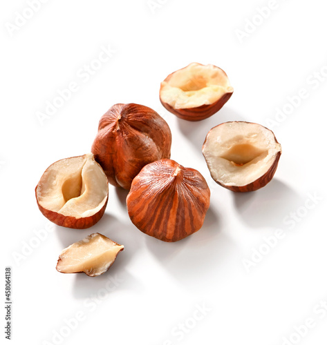 peeled hazelnuts group whole, half and part close-up  isolated on white background with shadow 
