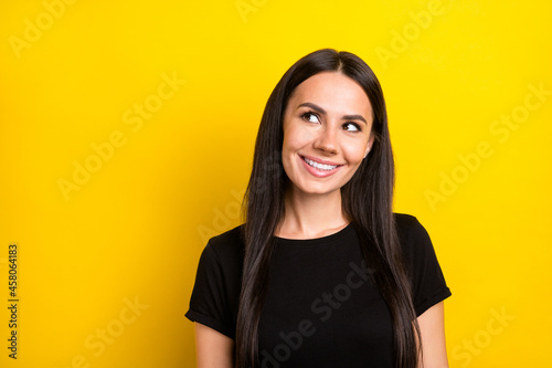 Photo of dreamy curious ladylook up empty space wear black t-shirt isolated yellow color background photo