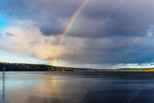 lake after rain with a rainbow over it on a summer evening