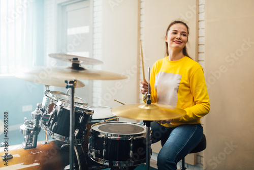Young female drummer playing a drum kit. photo