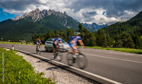 Cyclists riding a bicycle on the road in the background the Dolomites Alps Italy.