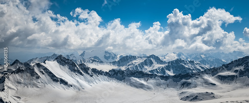 Mountain clouds over beautiful snow-capped peaks of mountains and glaciers. View at the snowy mountains. © Andrey Armyagov