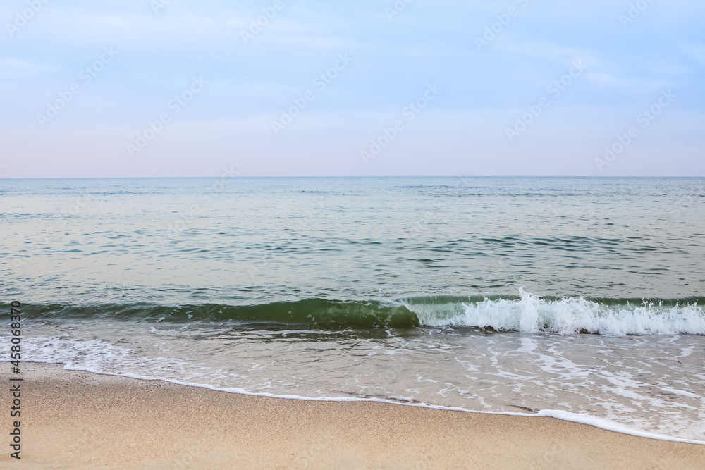 Beautiful sea summer abstract background. Golden sand beach with blue ocean and cloudscape and sunset in the back.
