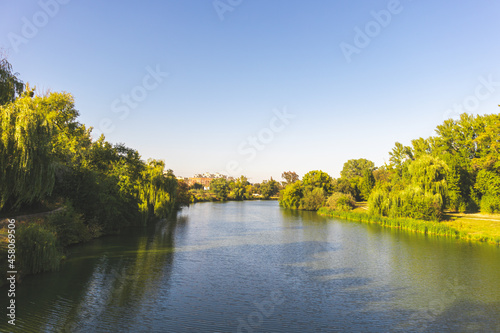 Village river at sunset, clear blue sky above photo